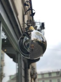 Close-up of crystal ball hanging on glass building
