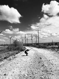 Man walking on field against sky