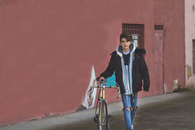 Young teenager with vintage bike on city street