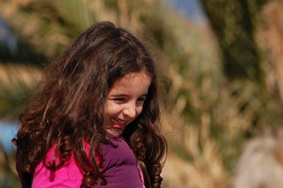 Close-up of cute girl looking away and smiling