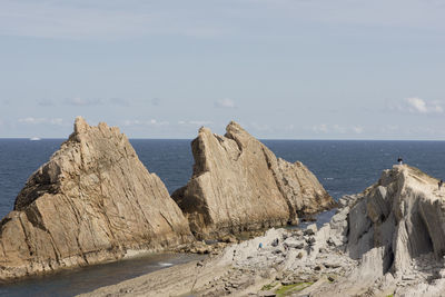 Scenic view of sea and cliff against sky