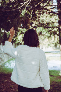 Rear view of girl standing against trees