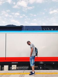 Full length of man standing on train against sky
