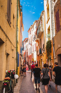 People walking on street amidst buildings in city