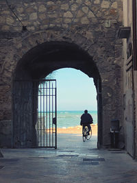 Rear view of people walking in tunnel