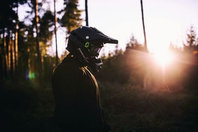 Rear view of man photographing at sunset