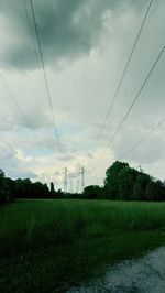 Electricity pylon on field against sky