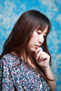 Close-up portrait of a white-haired asian woman with long brown hair posing thinking with in studio