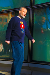 Man looking away while standing on glass