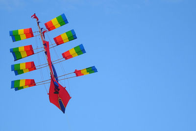 Low angle view of flag against clear blue sky