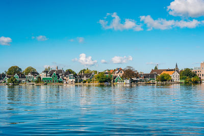 Houses by sea against blue sky