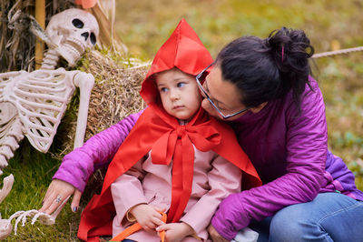 Young girl in a halloween red riding hood costume taking pictures at the fair