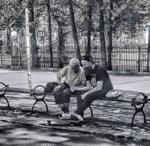 Two men sitting on tree