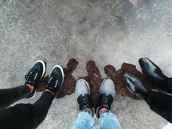 Low section of friends standing on wet road