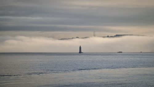 Scenic view of lighthouse in front of a fog bank