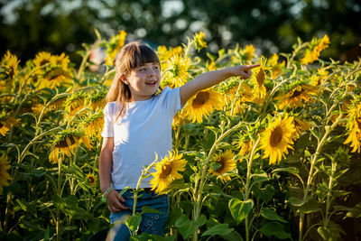 Full length of girl standing in sunflower