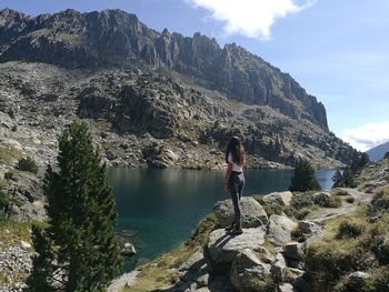 Woman standing on rocks against mountain