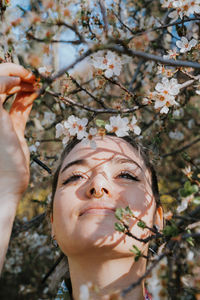 Portrait of young woman with cherry blossom tree