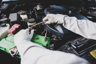 Mechanic repairing car engine in garage