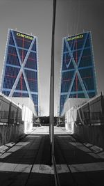 Suspension bridge in city against sky