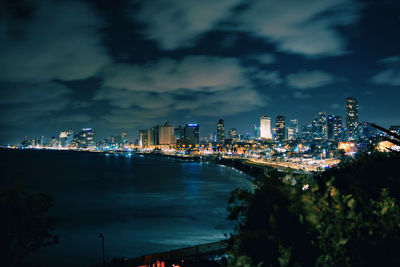 Illuminated buildings in city against sky at night