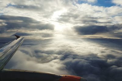 Cropped image of airplane against cloudy sky