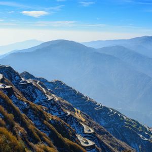 Scenic view of mountains against blue sky