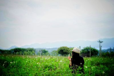 Woman standing on field against sky