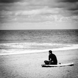 Male surfer sitting on the beach