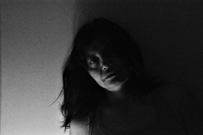 Close-up portrait of young woman against wall