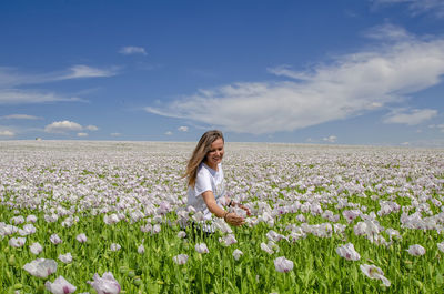 Rear view of woman on grassy field against sky