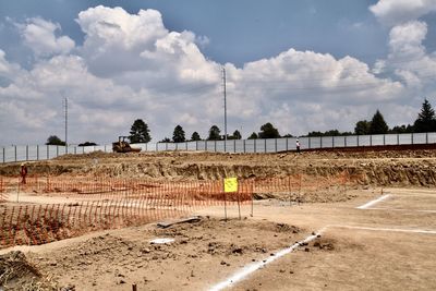 Panoramic shot of construction site on field against sky