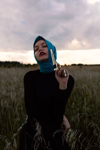 Full length of woman standing on field against sky