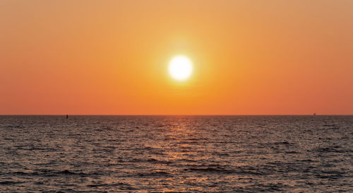 Scenic view of sea against orange sky