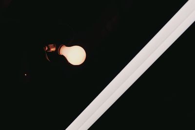 Low angle view of illuminated lamp at night