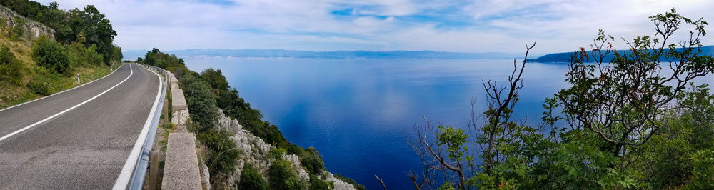 Panoramic view of road by sea against sky