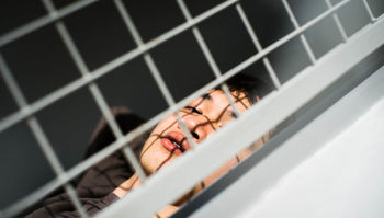 HIGH ANGLE PORTRAIT OF WOMAN ON METAL GRATE