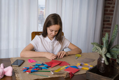 A beautiful teenage girl makes origami