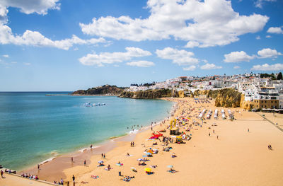 High angle view of beach by houses against cloudy sky