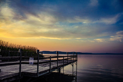 Pier over sea against sky during sunset