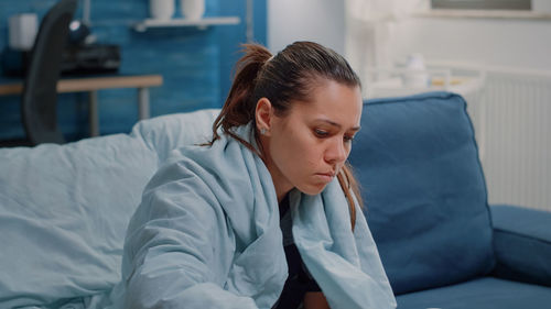 Sick woman resting on sofa at home