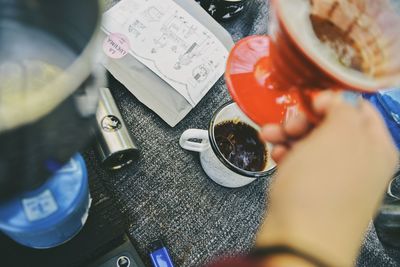 High angle view of hand holding drink on table