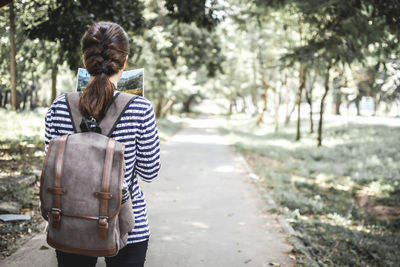 Rear view of woman standing in forest