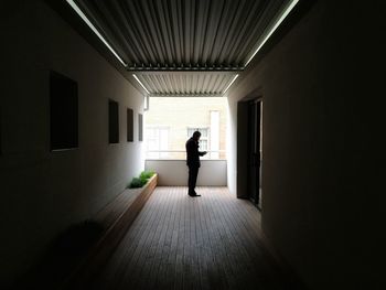 Rear view of silhouette woman walking in corridor