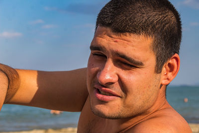 Close-up portrait of young man at beach
