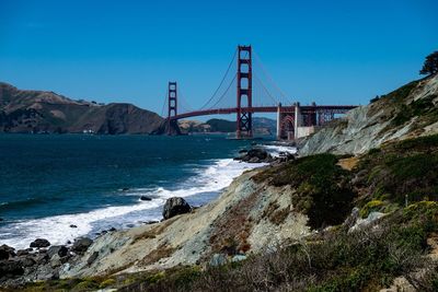 View of suspension bridge against blue sky