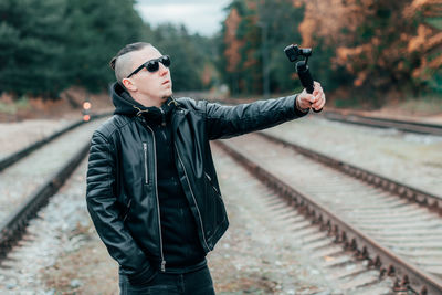 Full length of young man standing on railroad track