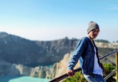 Man standing on mountain against clear blue sky