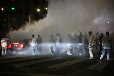 People standing on illuminated street at night