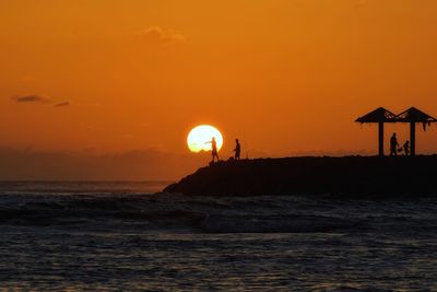 Scenic view of sea against orange sky